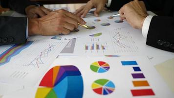 Businessman examining graphs with other working people. video