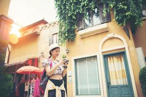 Mujer joven inconformista disfrutando de tomar una foto en el entorno urbano