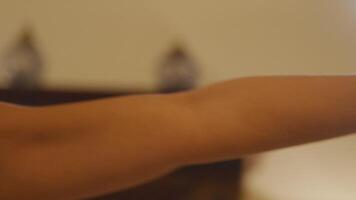 Close up of hand, arm and face of Mature Asian woman, practicing yoga. Fingers and arm are stretched, arm moves above her head, head and eyes following the stretched arm. video