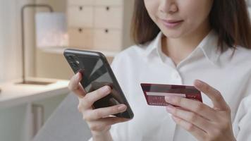 mulher segurando smartphone e cartão de crédito video