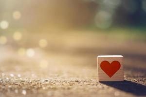 Wooden cube with heart sign icon and copy space with natural sunlight photo