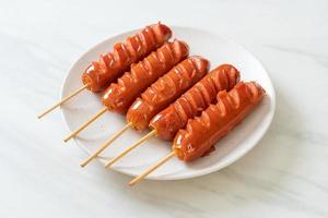 Fried sausage skewer on white plate photo