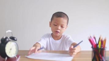 boy sitting and doing homework, drawing, coloring video