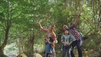 la familia trajo a dos hijos de excursión usando binoculares para aprender la naturaleza durante las vacaciones en el centro de estudio de la naturaleza. video