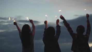 Mulher asiática segurando estrelinhas comemorando ano novo com amigos video