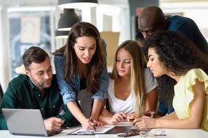 Multi-ethnic group of young men and women studying indoors. photo
