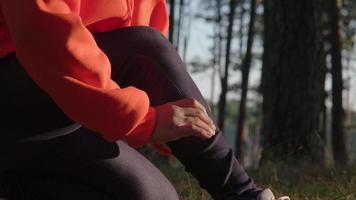 A female runner is massaging her cramping legs while running. Athletes injured during exercise. Health and sports concept. video