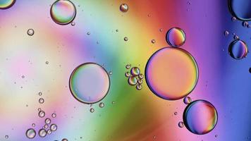 abstracte kleurrijke voedselolie druppels bubbels en bollen stromen op het wateroppervlak, macro videografie video