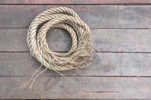 The rope rests on a wooden background photo