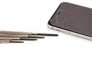 teléfono inteligente roto y destornilladores pequeños para reparar foto