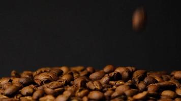 rallentatore di chicchi di caffè tostati che cadono. semi di caffè biologico. video