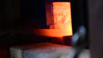 Man hitting a red metal. Making a blade of a knife in Black smith video