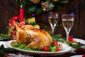 pavo o pollo al horno. la mesa navideña se sirve con un pavo, decorado con oropel brillante y velas. pollo frito, mesa. cena de Navidad. foto