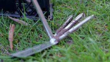 hachoir à râteau à outils de jardin pour le jardinage sur fond de boîtes en plastique. le concept de jardinage et d'été durable. outil de jardin en métal avec un râteau et une houe sur fond naturel. video
