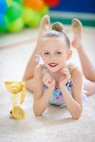 Beautiful little gymnast training on the carpet and ready for competitions photo