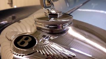 detailopname van een bentley s1 insigne Aan de kap van een 1950 vliegend uitloper luxe sedan. de logo is gemaakt in de het formulier van een brief b met verspreiding Vleugels. inbaar model. Oekraïne, kiev - juni 04, 2021. video