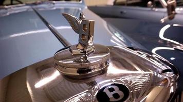 detailopname van een bentley s1 insigne Aan de kap van een 1950 vliegend uitloper luxe sedan. de logo is gemaakt in de het formulier van een brief b met verspreiding Vleugels. inbaar model. Oekraïne, kiev - juni 04, 2021. video