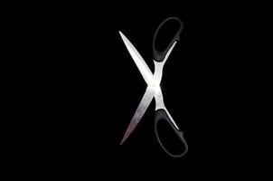 Scissors on black background photo