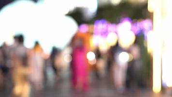 pessoas caminhando por aí para uma festival luz acima evento, Fora do foco fundo, desfocado luzes bokeh fundo video