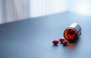 rojo cápsula pastillas y marrón el plastico fármaco botella. codeína y guaifenesina cápsula pastillas a aliviar tosiendo tos medicamento. opioides o narcóticos drogas prescripción droga. tos supresor medicamento. foto