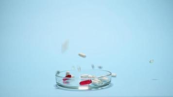 schleppend Bewegung. Weiß medizinisch Tabletten und rot durchscheinend Gelatine Kapseln zum Schweben. pharmazeutische Tabletten fallen Nieder auf Petri Gericht, isoliert auf Blau Hintergrund. Welt Apotheker und Gesundheit Tag Konzept video