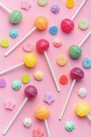 Sweet lollipops and candies on pink background photo