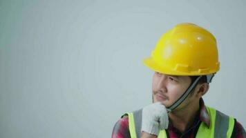 Asian young engineer wearing a yellow safety goggles and safety vest. looking to the side and smiling. video