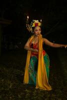 portrait of a traditional Sundanese dancer dancing with an orange scarf hanging down her body photo