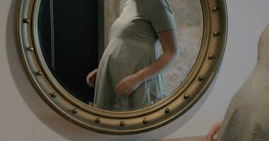 Enceinte femme à la recherche à miroir et caressant ventre video