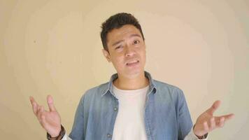 Young Indonesian man wear denim clothes with why pose and gesture.  The footage is suitable to use for man expression and healthy lifestyle content media. video