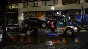 Chicago, USA - - Januar 28, 2021 LKW ist Abschleppen ein Auto beim Winter Nacht. Chicago Schleife video