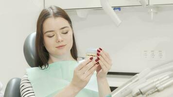 Happy young beautiful woman holding dental model smiling to the camera video
