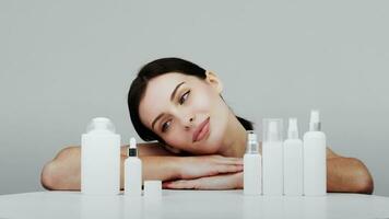 Woman showing cosmetic products branding mockup. Daily skincare and body care routine. Natural cosmetic cream, serum, white bottles packaging, bio organic product. video