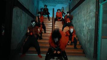 Group of people in red and black costumes with masks dancing in a stairwell. video