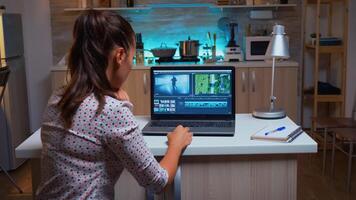 Young sound engineer working on video footage during post production. Content creator in home editing on montage of film using modern software for processing late at night. photo