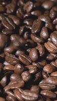 Vertical slow motion of roasted coffee beans falling. Organic coffee seeds. video