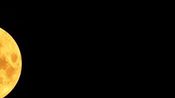 A glowing golden huge full moon seen from earth through the atmosphere against a starry night sky. A large full moon moves across the sky, the moon moving from the bottom left frame to the top right. video