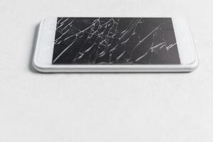 moderno móvil teléfono inteligente con roto pantalla en blanco antecedentes foto