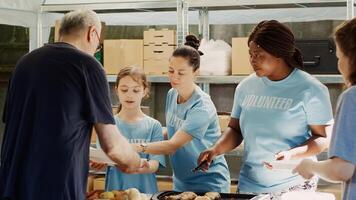 generoso voluntarios proporcionar comida y donaciones para hambriento y Vagabundo gente. a comida conducir, tipo pequeño niña y otro hembra caridad trabajadores distribuido gratis comidas a el necesitado. trípode disparo. foto