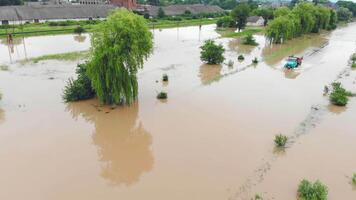 Ucrânia. galichão 24 Junho 2020. aéreo Visão carro dirigindo em uma inundado estrada dentro a Vila. a carro carrega carga a partir de inundado casas durante uma enchente. video