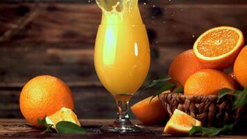 super lent mouvement Orange jus verse jet dans le verre. filmé à 1000 fps.on une en bois Contexte. video