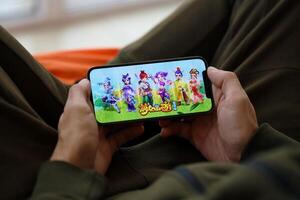 Fantasy Westward Journey mobile iOS game on iPhone 15 smartphone screen in male hands during mobile gameplay photo