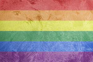 Rainbow LGBTQ or gay pride flag on decorative plaster or concrete texture. Abstract background. photo