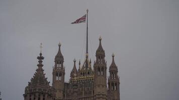 il Britannico bandiera svolazzanti sopra il palazzo di Westminster, Londra, UK. video