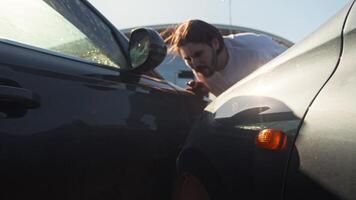 dentro a primeiro plano, lá é uma virar sinal e a emergência luz piscando depois de a acidente envolvendo dois carros. a motorista é avaliando a dano. meio tomada. lento movimento video