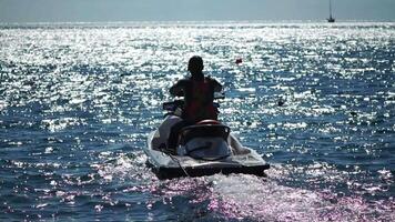 content gens nager sur air matelas derrière une haute la vitesse l'eau vélo. touristes balade sur gonflable motomarine bateau. mer attraction. noir mer, Crimée - 04 SEP 2022 video
