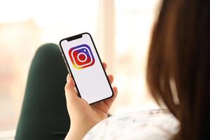 KYIV, UKRAINE - APRIL 1, 2024 Instagram icon on smartphone screen in young female hands photo