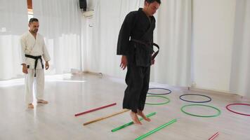 dois homens trem com pulando obstáculo exercícios durante karatê Treinamento video