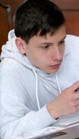 étudiant aide jolie ami avec rouge cheveux faire devoirs séance dans bibliothèque, utilisation ordinateur portable, préparer Nouveau projet, à la recherche pour Nouveau recherche sujet, étude ensemble, en utilisant moderne les technologies video