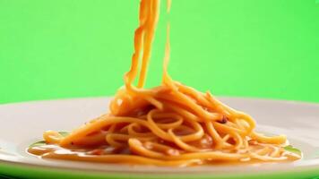 spaghetti con pomodoro salsa caduta su piatto verde schermo sfondo. video